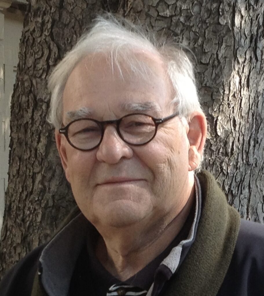 Portrait de Jacques Besner, devant un tronc d'arbre.