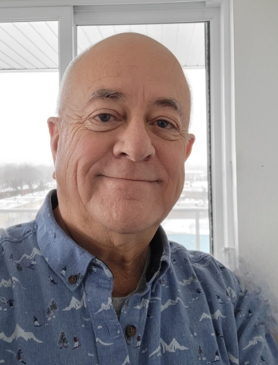 Portrait de Marcel M. Boucher, souriant, près d'une fenêtre.